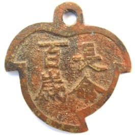 Peach charm with
      inscription "chang ming bai jiu" meaning "long life
      of 100 years"
