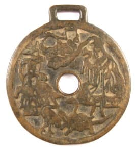 Obverse side
            of old charm with traditional symbols